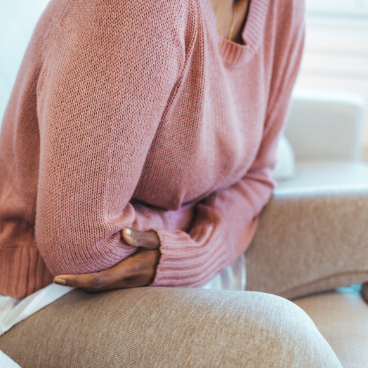 cropped shot of young woman with stomach pain